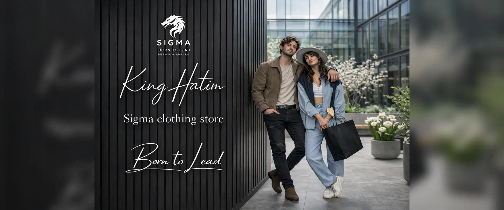 A black tote bag with a structured shape and sturdy handles, held by a woman in a light blue denim outfit.